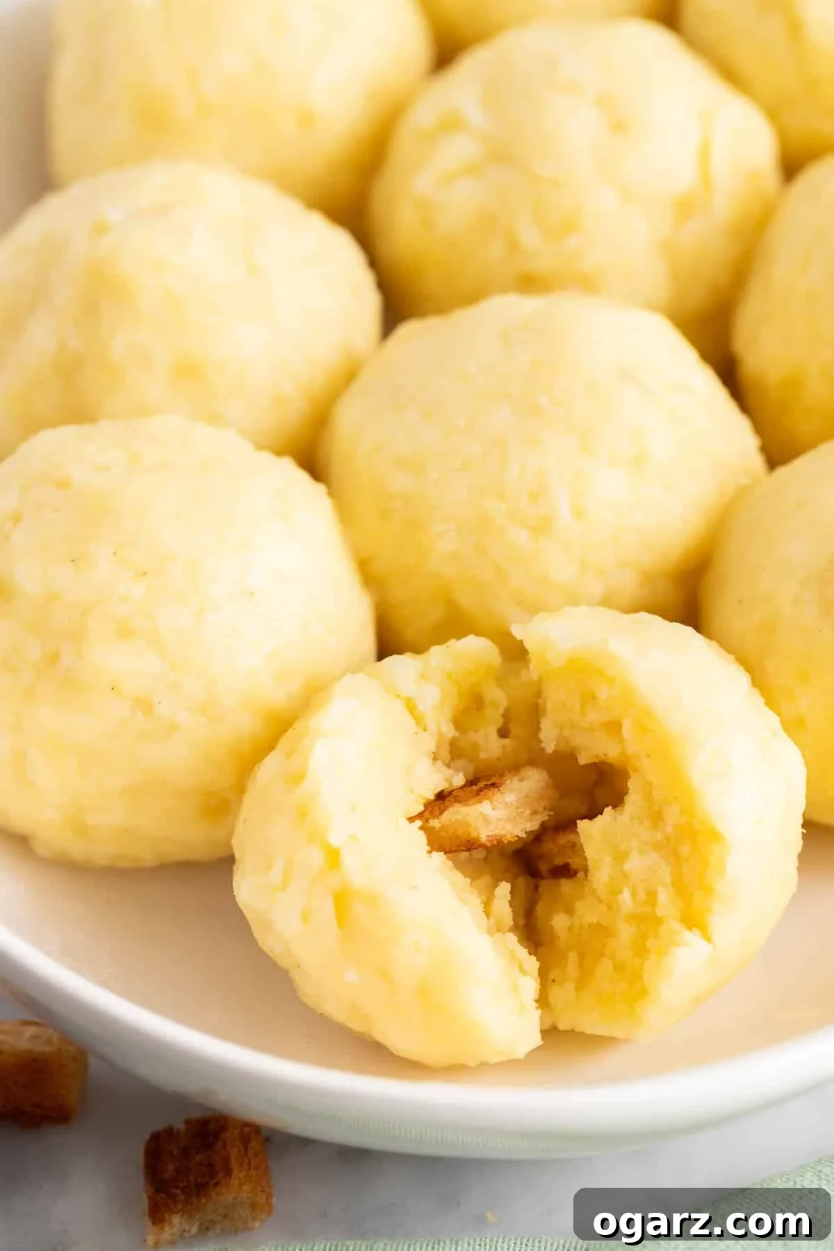 Pillowy Potato Bites 5 A freshly cooked Kartoffelkloesse, artfully ripped open with a fork, revealing its fluffy interior and readiness to absorb gravy.