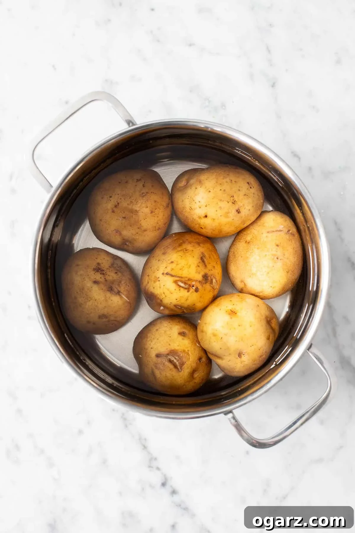 Pillowy Potato Bites 6 Unpeeled yellow potatoes resting in a large pot, ready to be cooked.