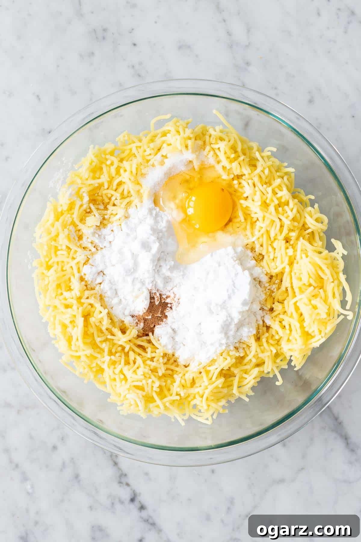 Pillowy Potato Bites 8 All the Kartoffelknoedel ingredients—riced potatoes, egg, potato starch, salt, nutmeg—being combined in a bowl.
