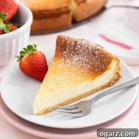 A slice of cheesecake on a white plate with a fork next to it.