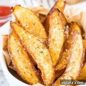 Air Fryer Potato Wedges in a white bowl, garnished with Parmigiano