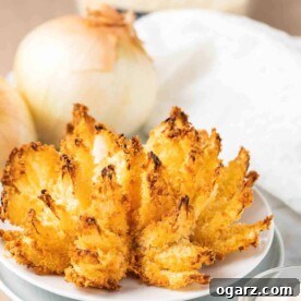 blooming onion on a white plate with onions in the background