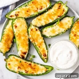 Jalapeno Poppers arranged on a white plate with a small bowl filled with a dip next to it