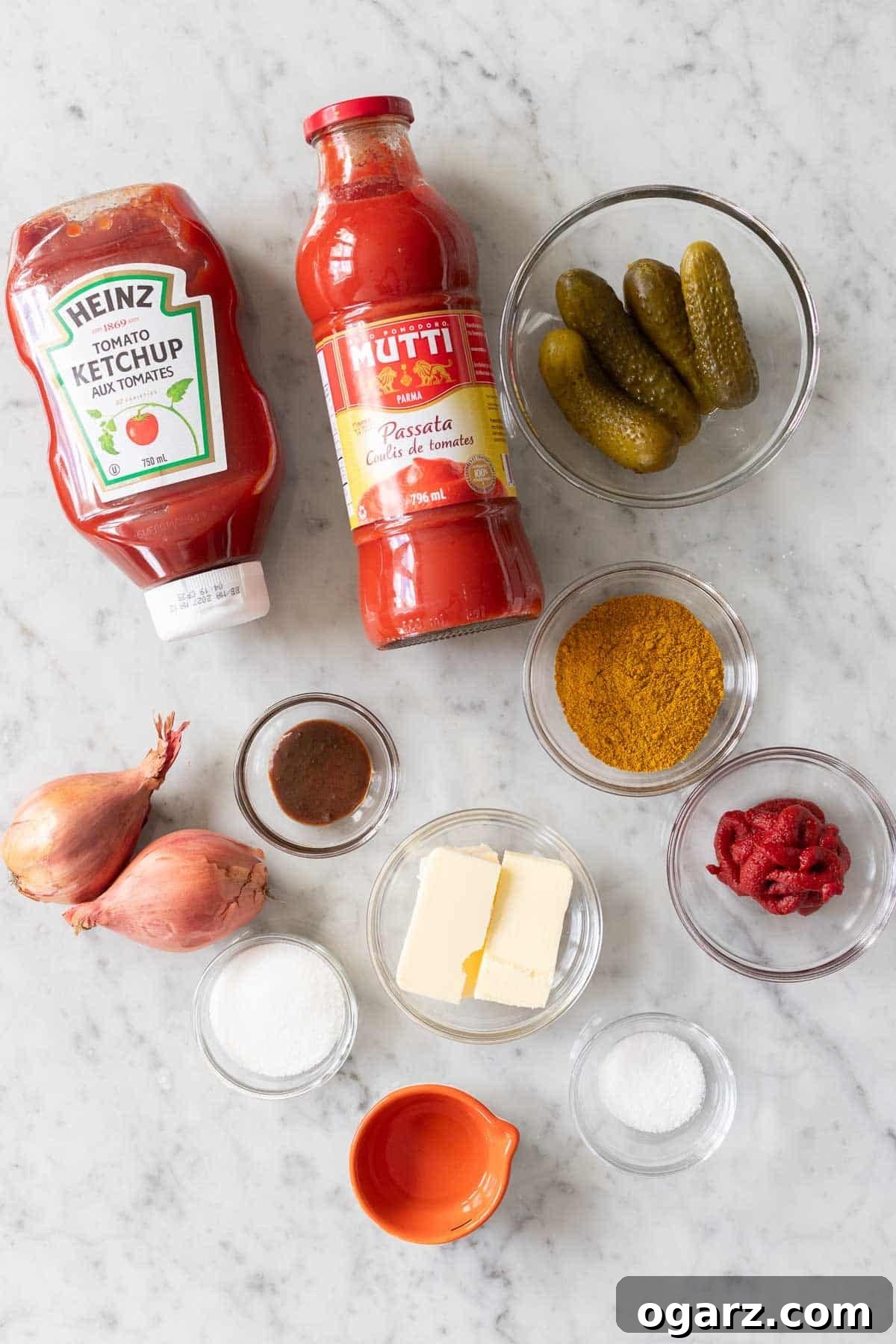 Ingredients for homemade currywurst sauce including passata, curry powder, and the secret ingredient: German pickles.