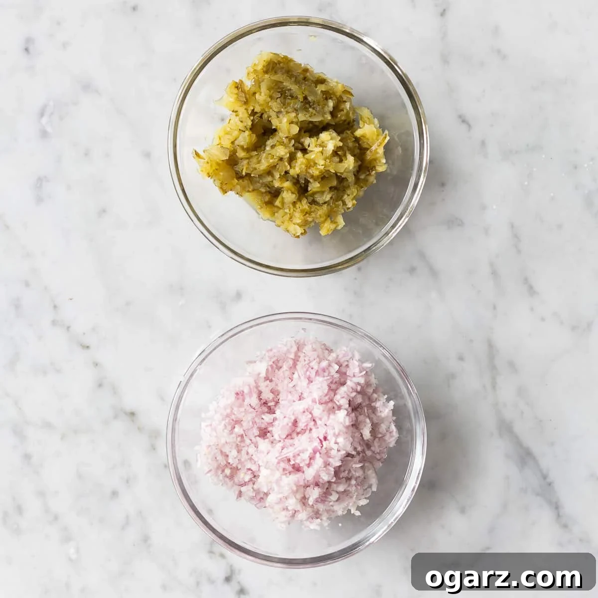 Finely chopped onions and pickles in two glass bowls.