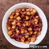 Caramelized apples and onions, with diced Granny Smith apples and red onion slices in a white bowl.